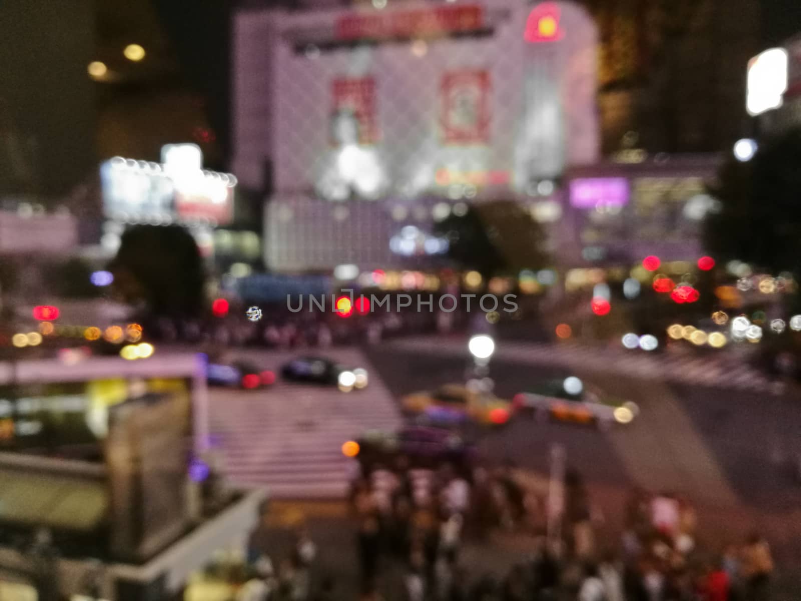 Defocused night scene of people crossing Shibuya intersection in Tokyo Japan