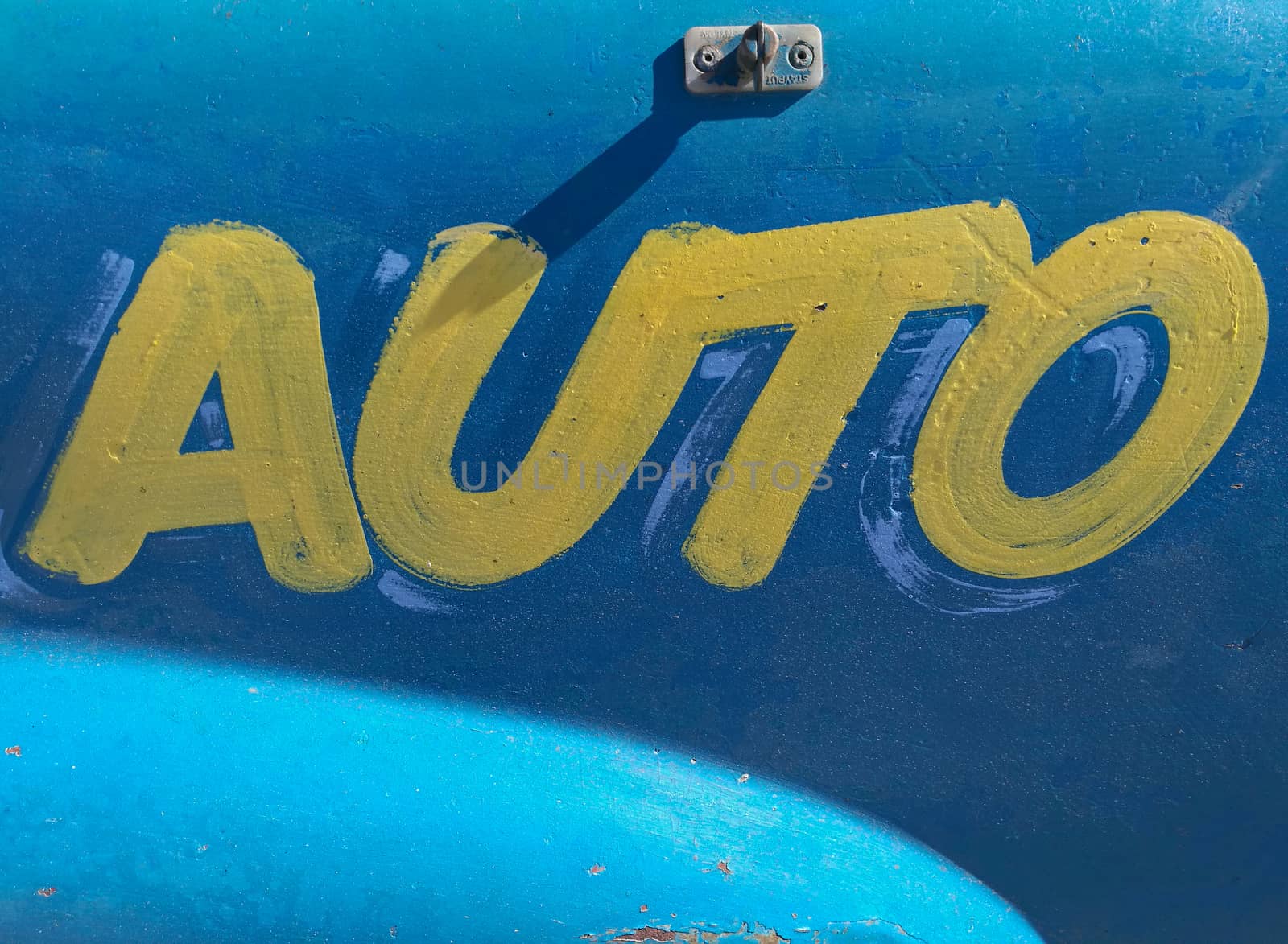 Auto yellow paint text on blue metal background by eyeofpaul