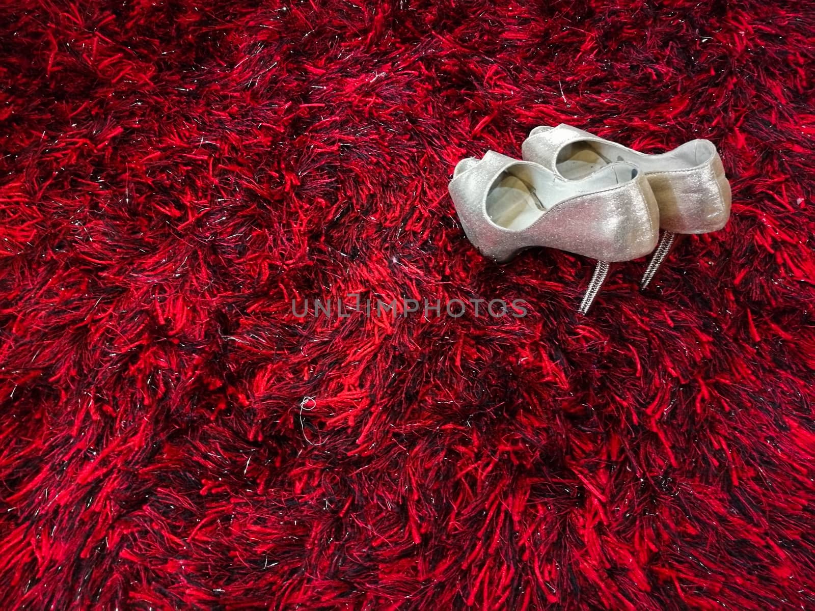 Silver shiny high-heeled shoes stiletto on red carpet