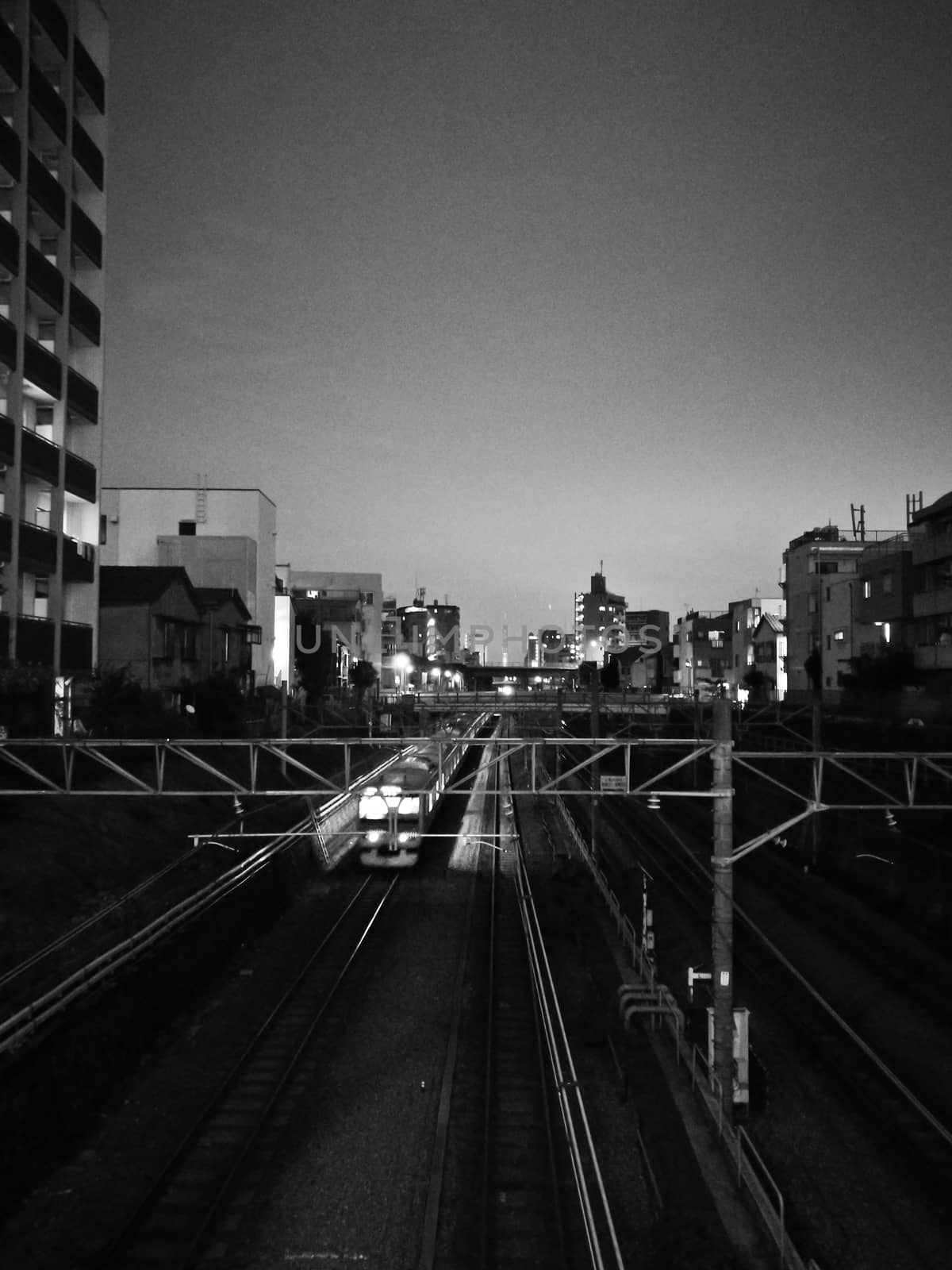 Moving motion scene of night train out of city center in black and white