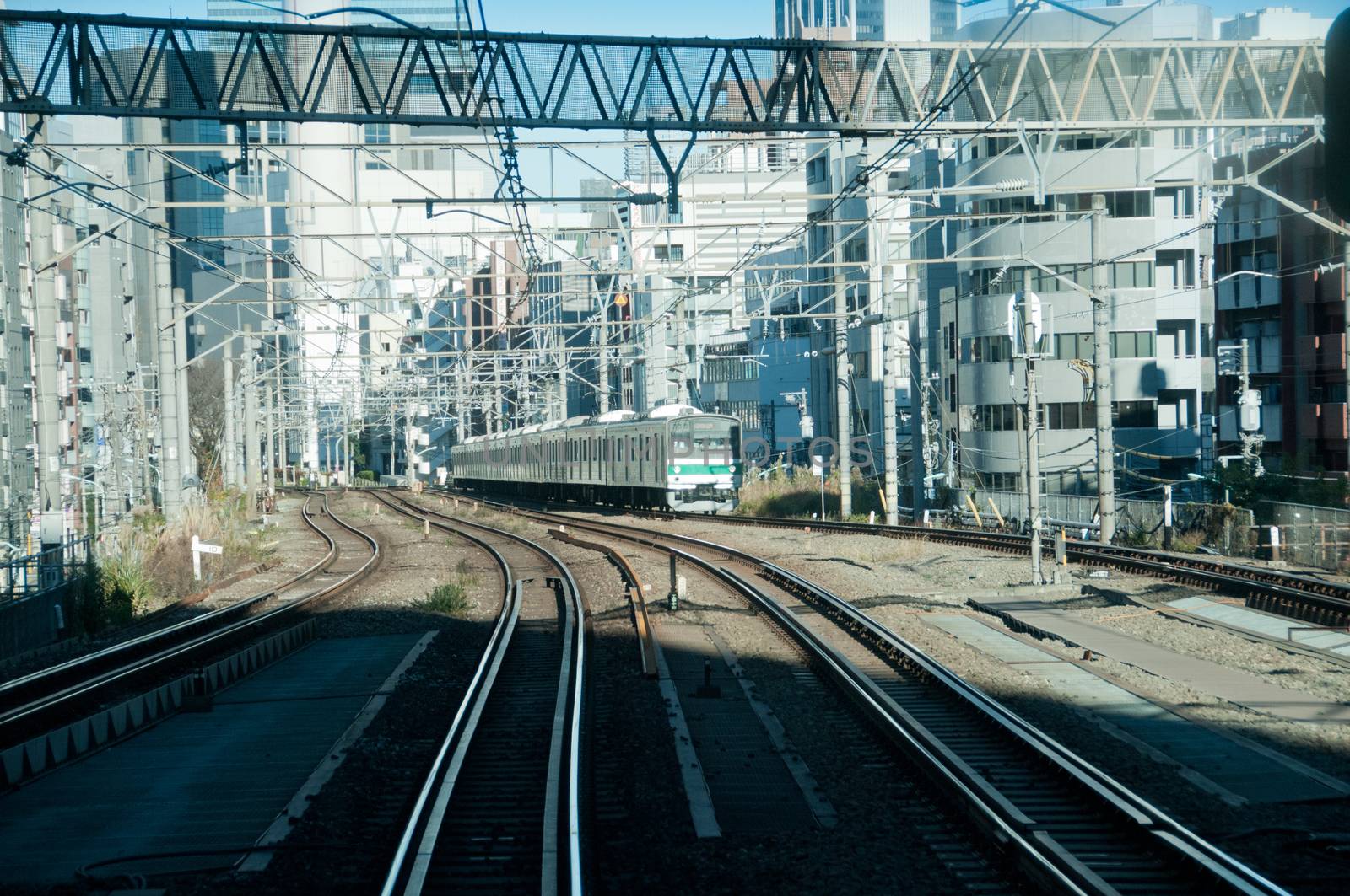 Complex railway tracks with upcoming train in Tokyo Japan by eyeofpaul