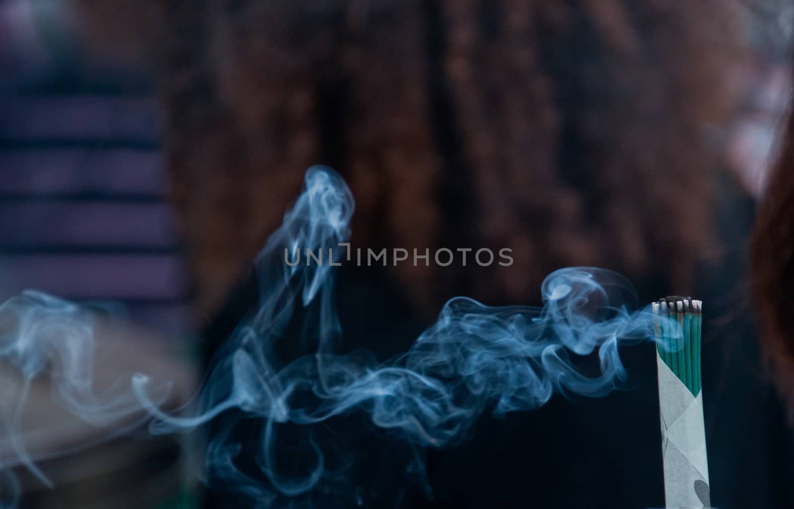 Close up scene of joss fragrant stick smoke in Asian temple