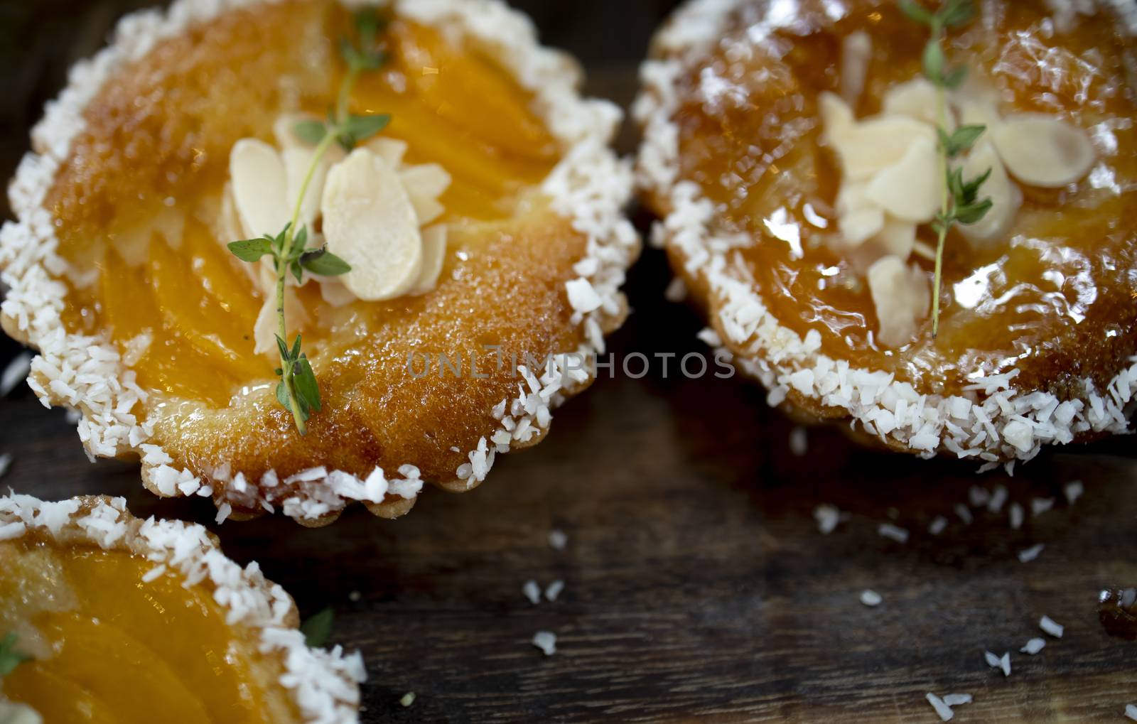 Peach tart with almond slices and coconut flakes.