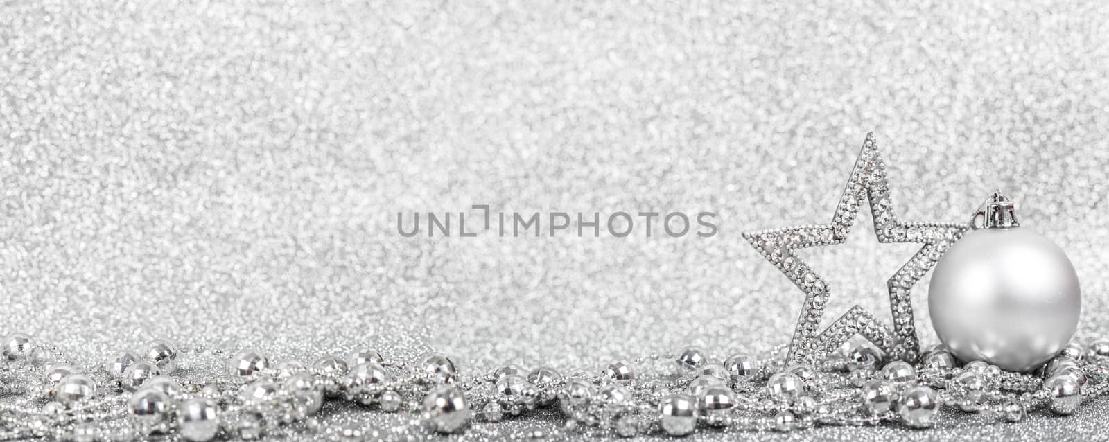 Christmas holiday composition of festive decor ball and star on silver glitter bokeh background