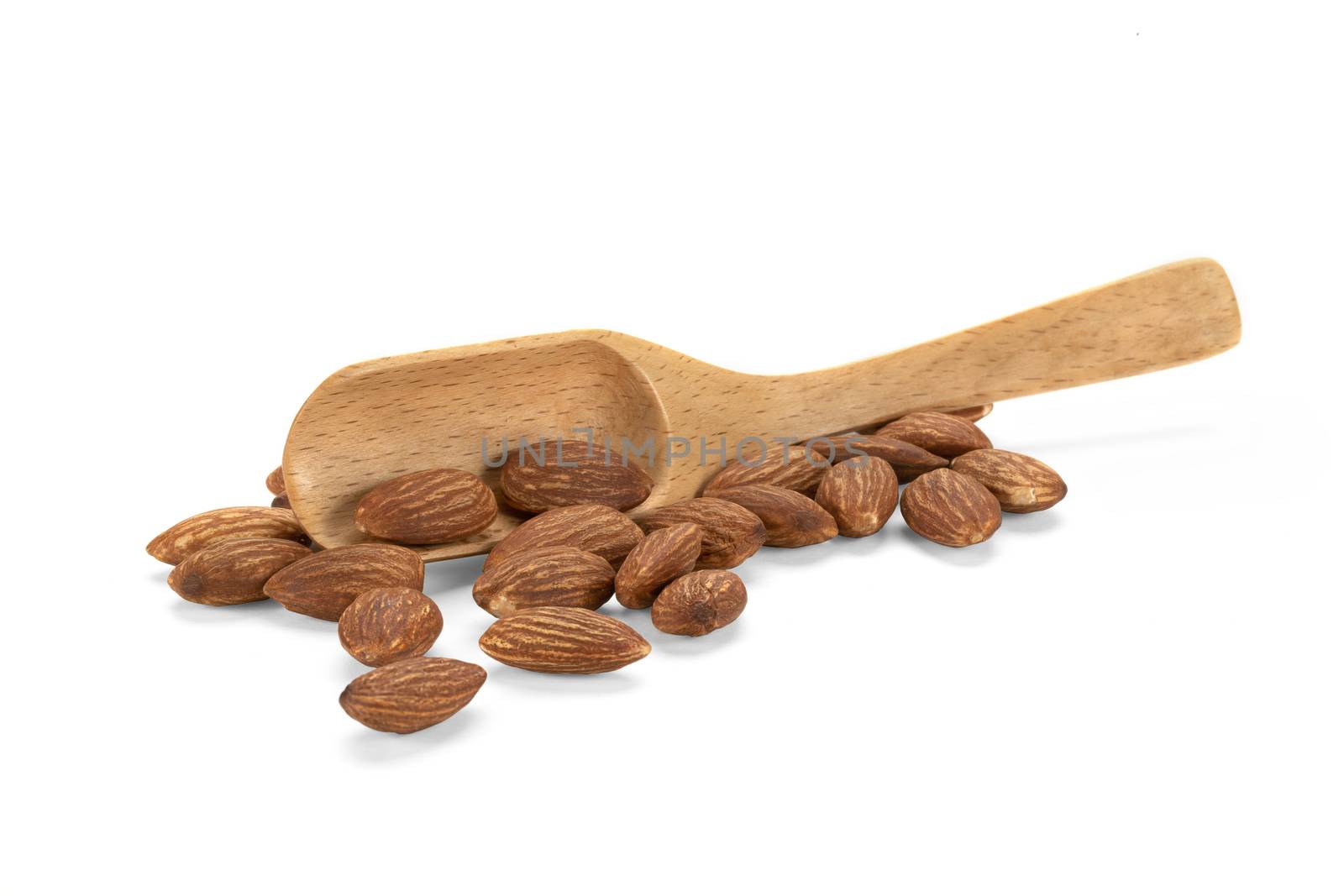 A heap of almonds and a wooden spatula on white background.
