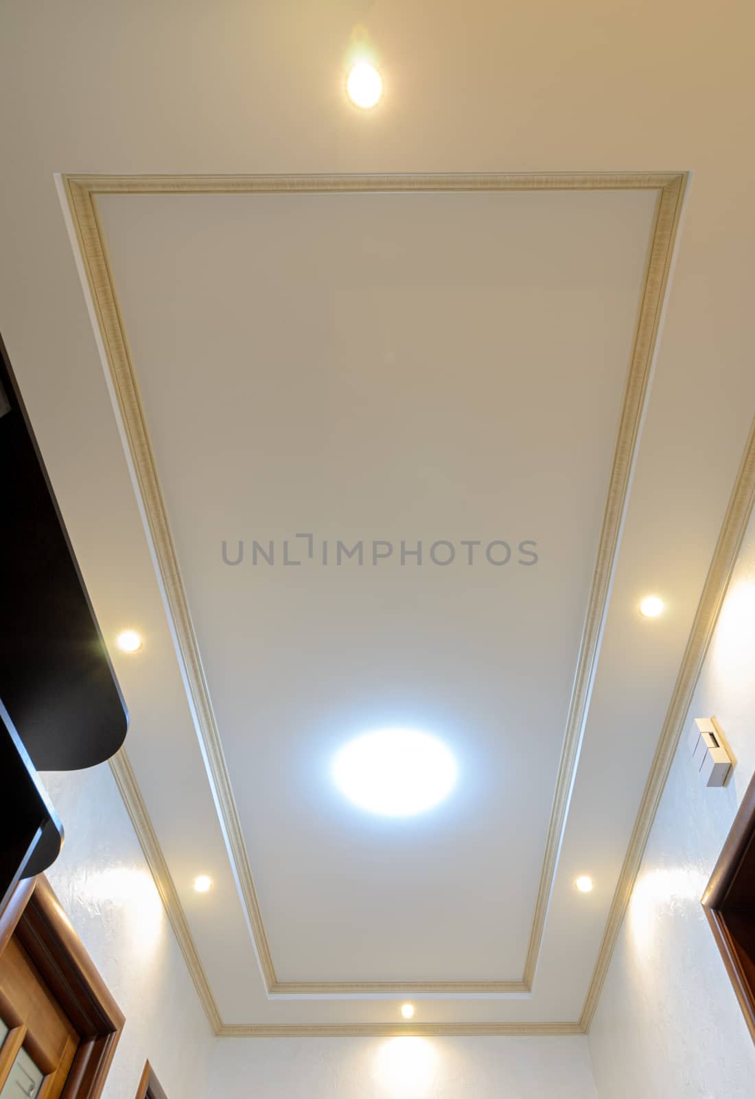 Original stylish multi-level ceiling in the hallway of the apartment