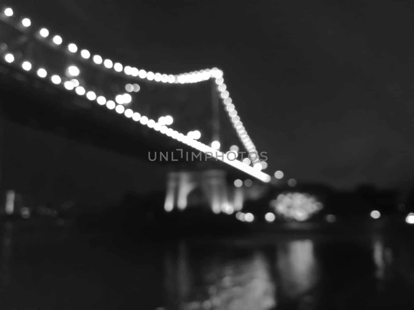 Defocused Iconic Brisbane Story Bridge with city skyscrapers at night in black and white