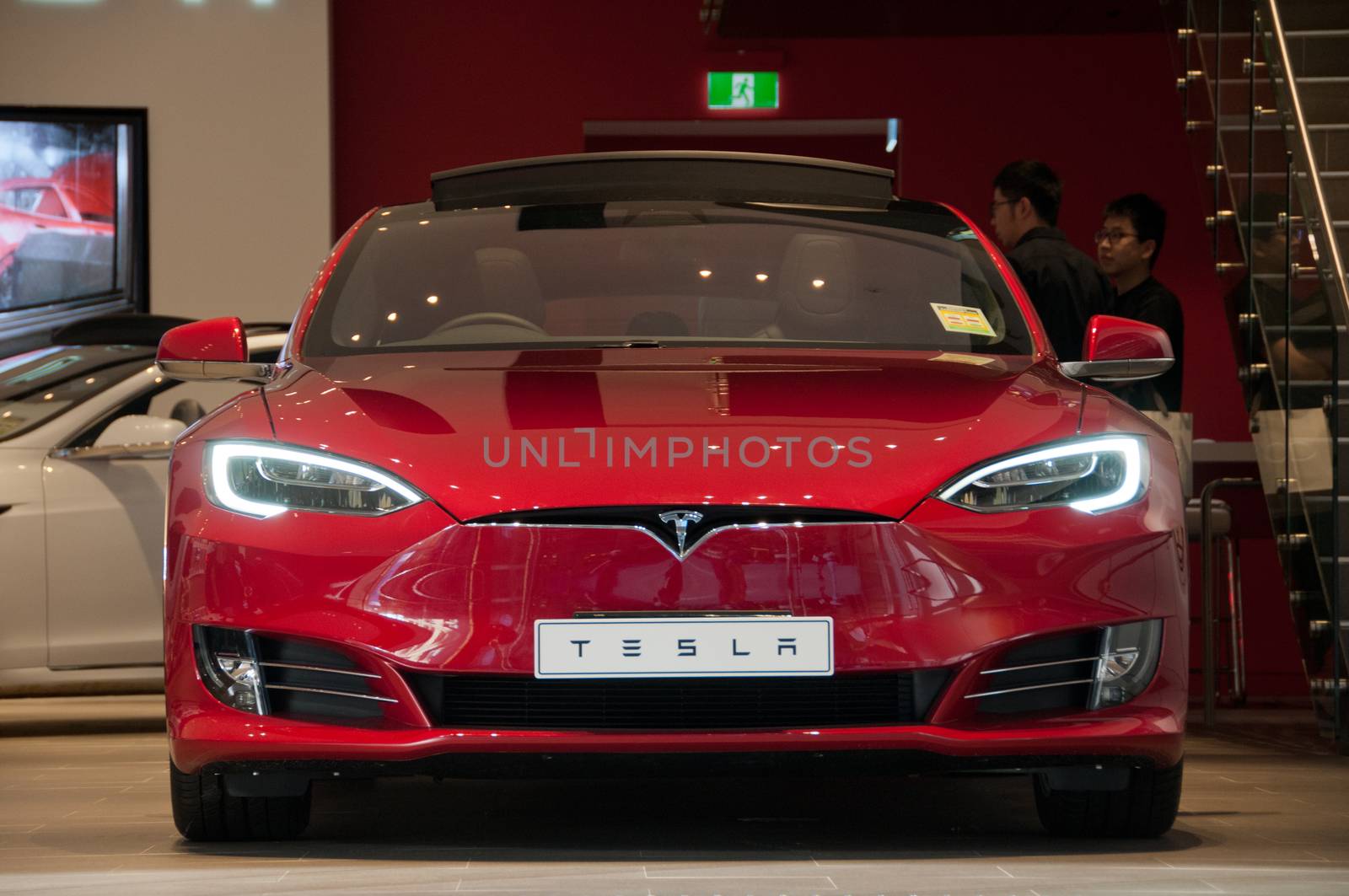 SYDNEY, AUSTRALIA - MAY 5, 2018: Tesla Model SP85 red colour park in a show room in Sydney NSW Australia building. There are people in the shop.