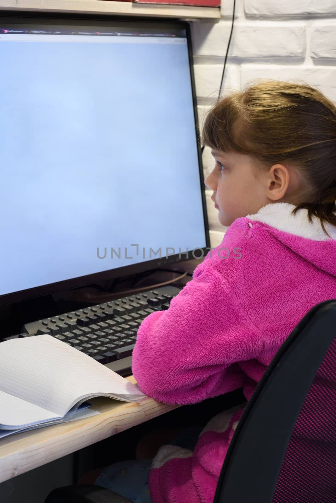 A girl studies at a computer with a large monitor, view from the by Madhourse