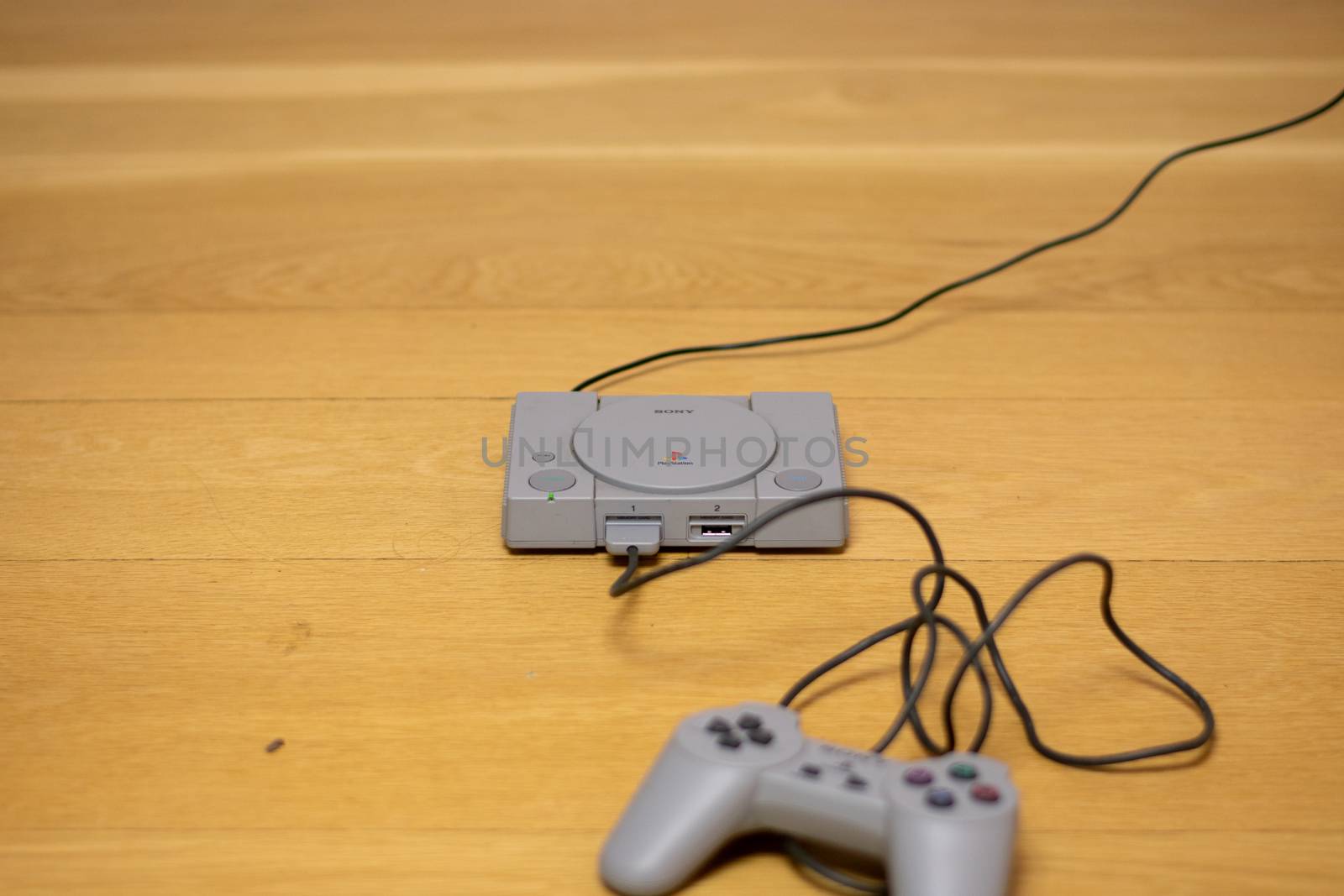 The Playstation Classic Edition. A recreation model of the original Playstation, On a Wooden Floor.