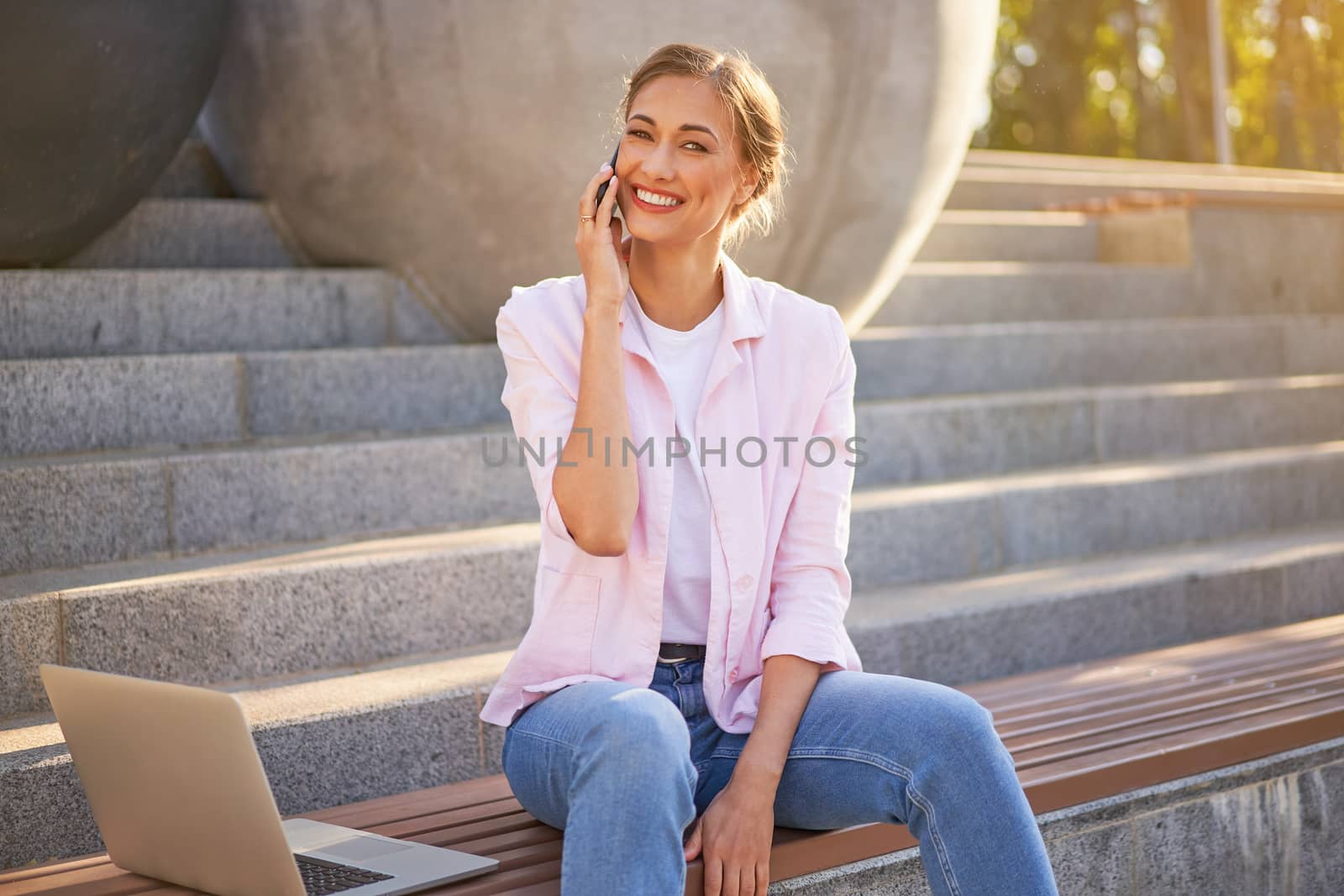 Businesswoman sitting stairs summer park using laptop and smartphone Business persone working remote. Outdoor. Successful Young european caucasian woman freelancer meeting online