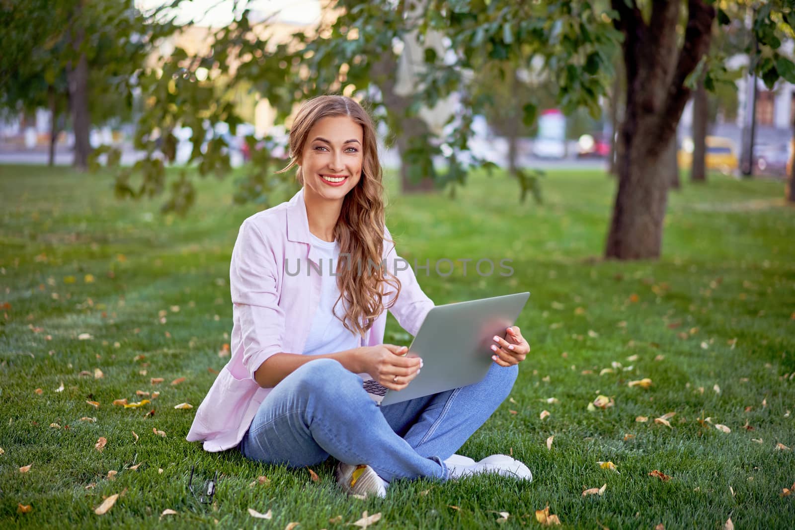 Businesswoman sitting grass summer park using laptop Business person working remote. Outdoors Successful european caucasian woman freelancer make video call teacher study work online lessons