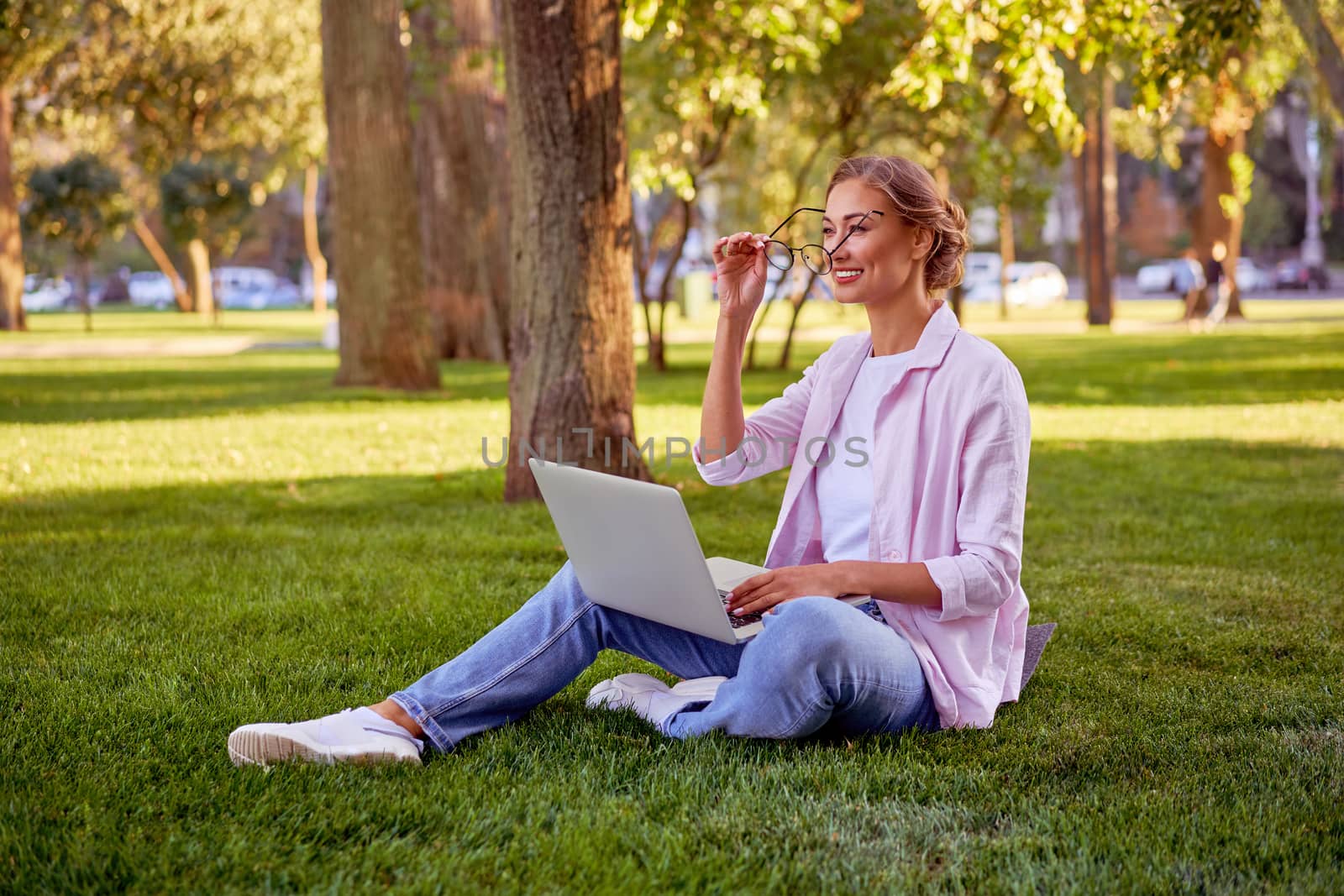 Businesswoman sitting grass summer park using laptop Business person working remote. Outdoor Successful european caucasian woman freelancer make video call teacher study work online lessons