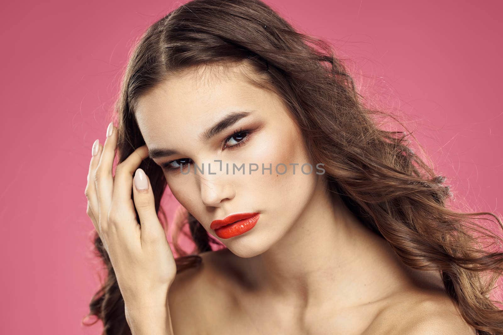 Attractive woman fashionable hairstyle bared shoulders and red lips pink background by SHOTPRIME