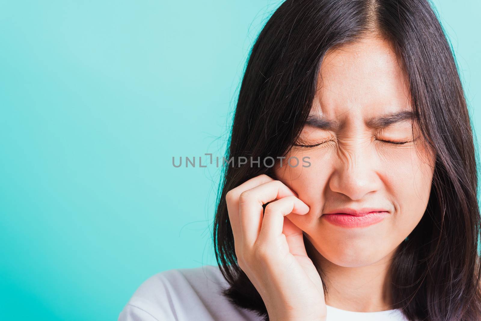 Portrait of Asian teen beautiful young woman smile have dental braces on teeth laughing she unhappy pain toothache and touch cheek by hand, isolated on blue background, Medicine and dentistry concept