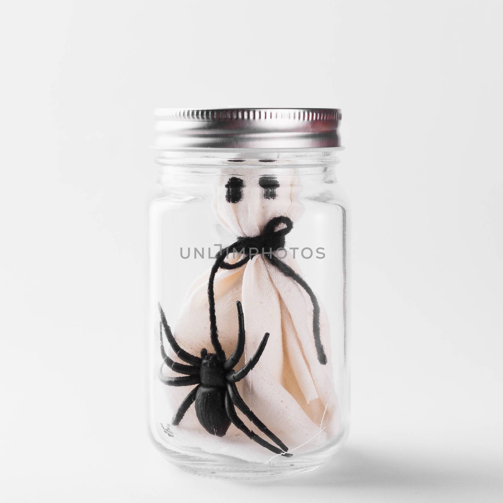 The white ghost scary face and black spider in jar glass by Sorapop