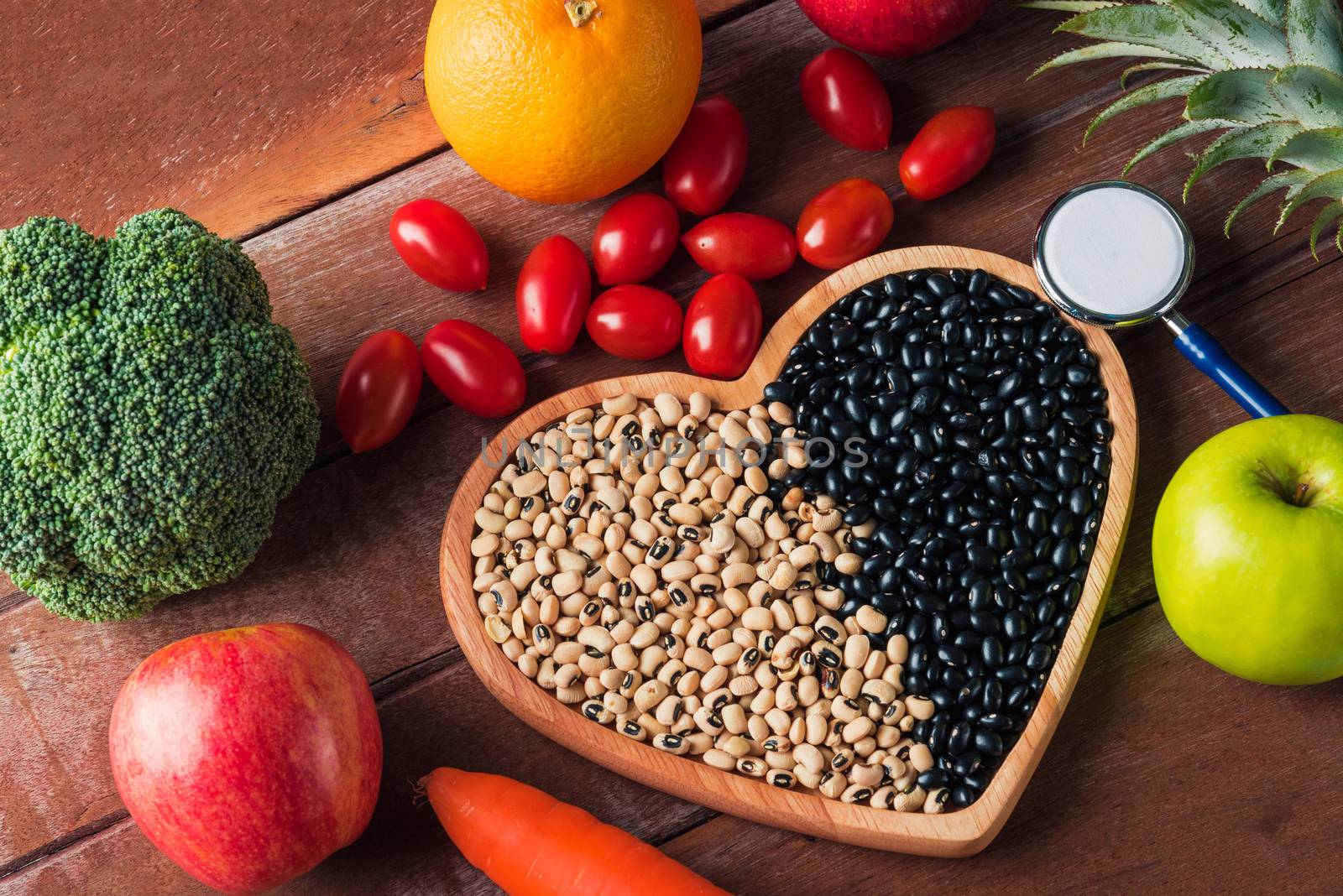 World food day, Top view of various fresh organic fruit and vegetable in heart plate and doctor stethoscope, studio shot on wooden table, Healthy vegetarian food concept