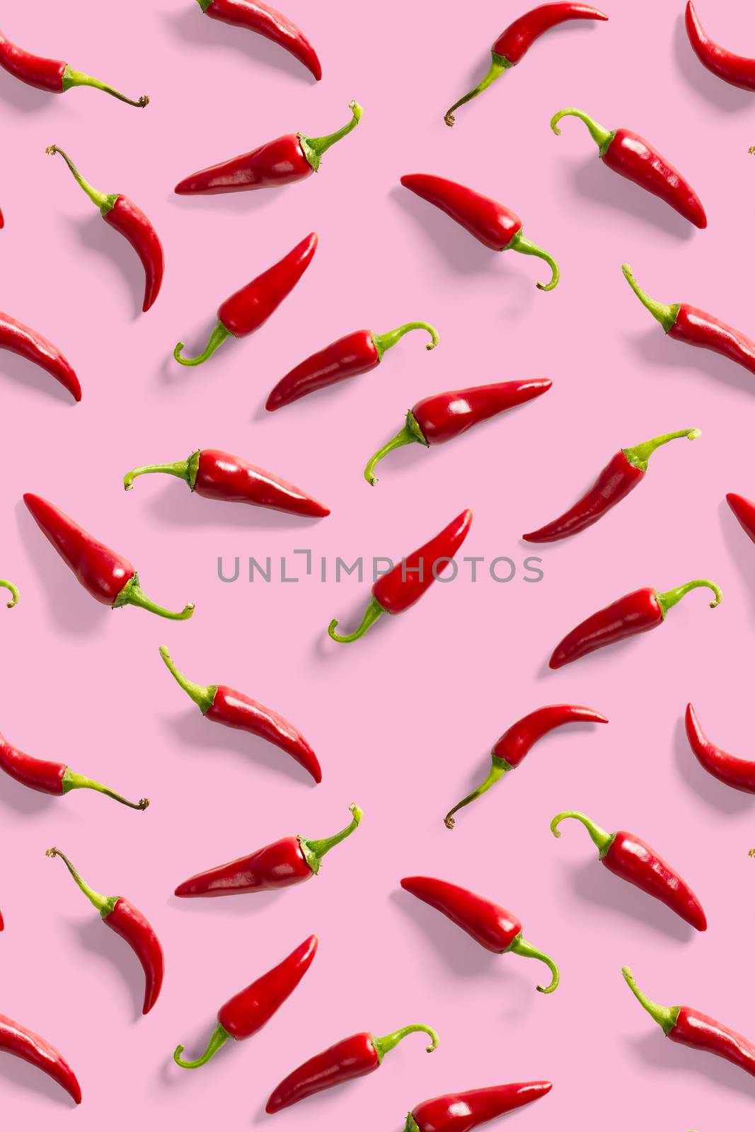 Creative background made of red chili or chilli on pink backdrop. Minimal food backgroud. Red hot chilli peppers background. by PhotoTime