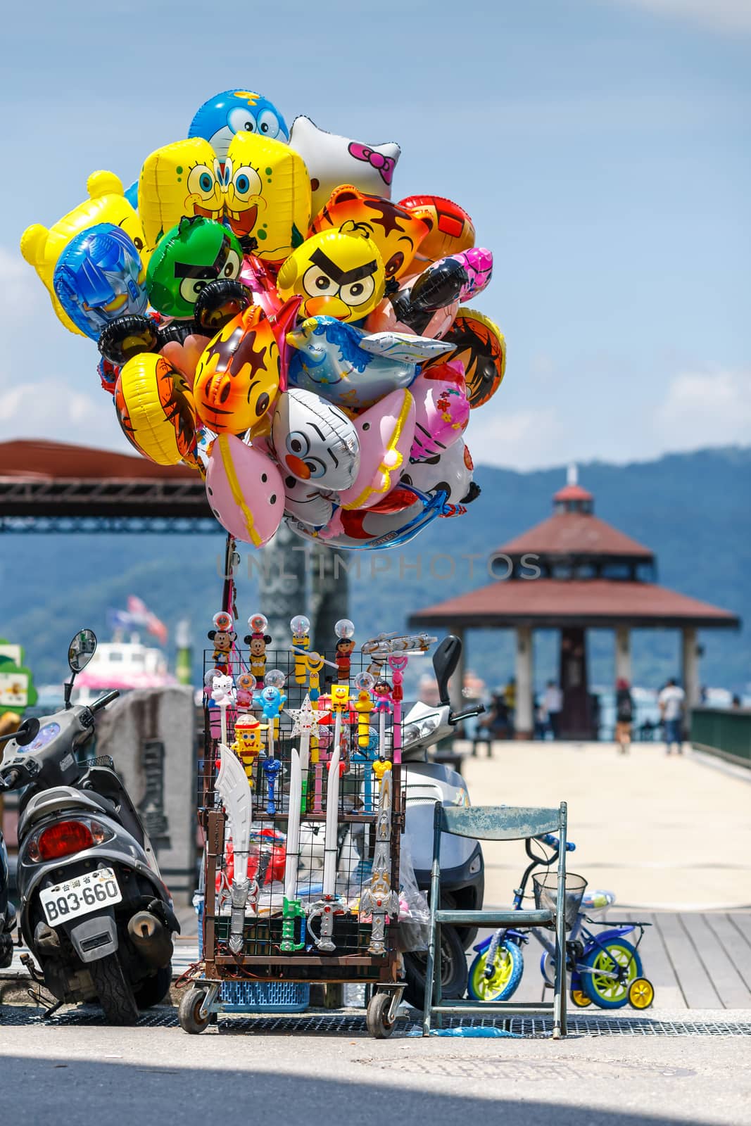 Colorful cartoon character balloon and kid toy hawker by street at Hop-On Hop-Off Boat pier in Sun Moon Lake, largest lake in Taiwan and tourist attraction.