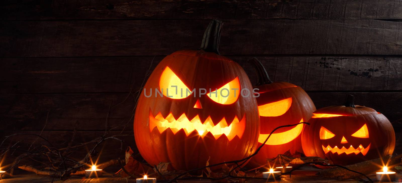 Halloween pumpkin head lantern and burning candles holiday celebration