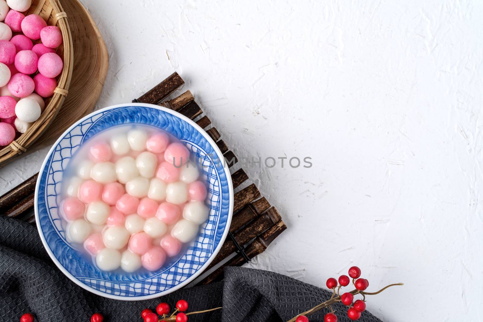 Top view of red and white tangyuan in blue bowl on white backgro by ROMIXIMAGE