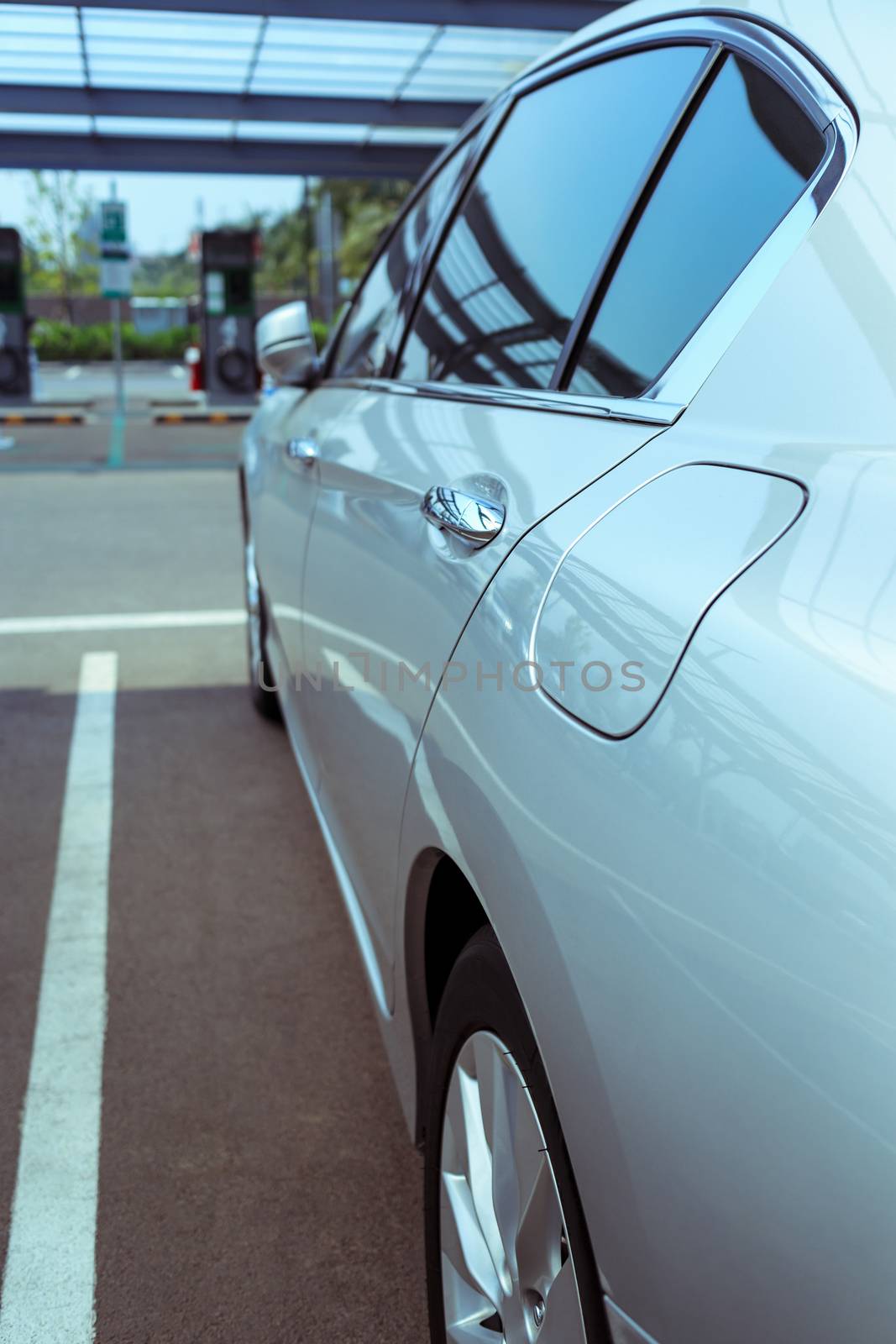 details of modern car, passenger door and small door to put in gasoline, closed fuel tank door on left hand side of car, selective focus