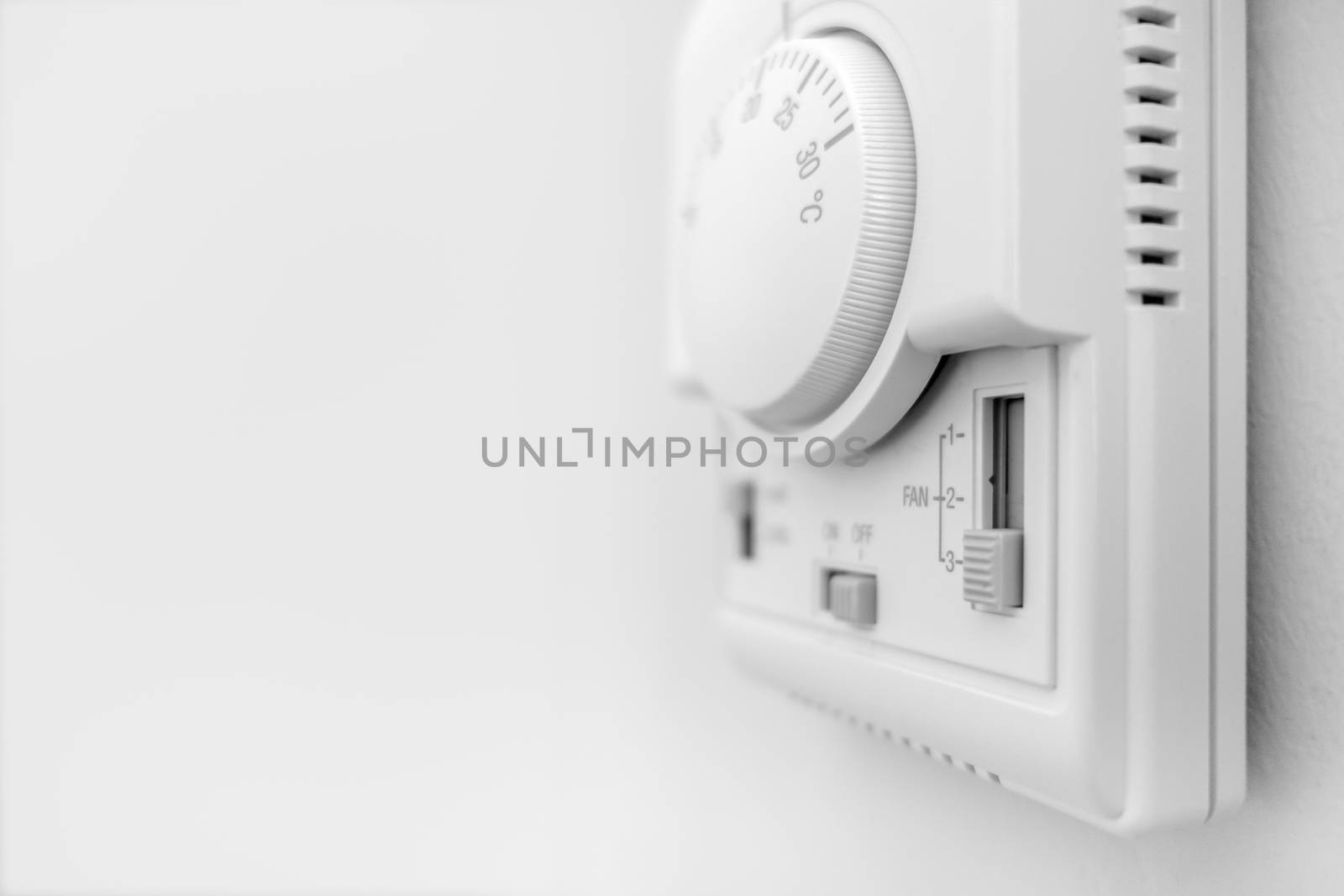 Hand adjusting thermostat. hand turning on thermostat climate control. Copy space. Defocused blurry background.