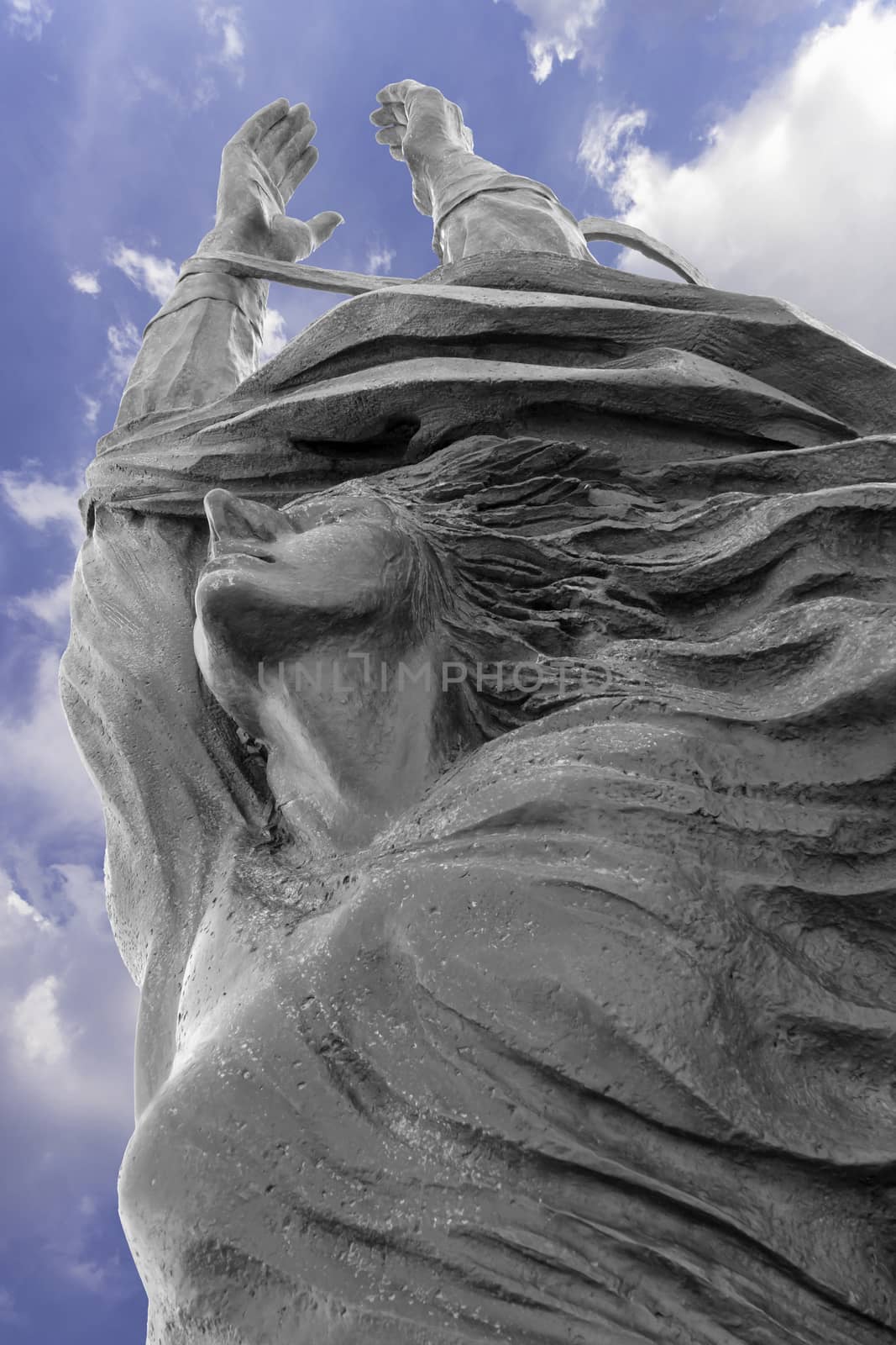 Statue of a woman with arms outstretched upwards. Peace, freedom, Easter concept and more.