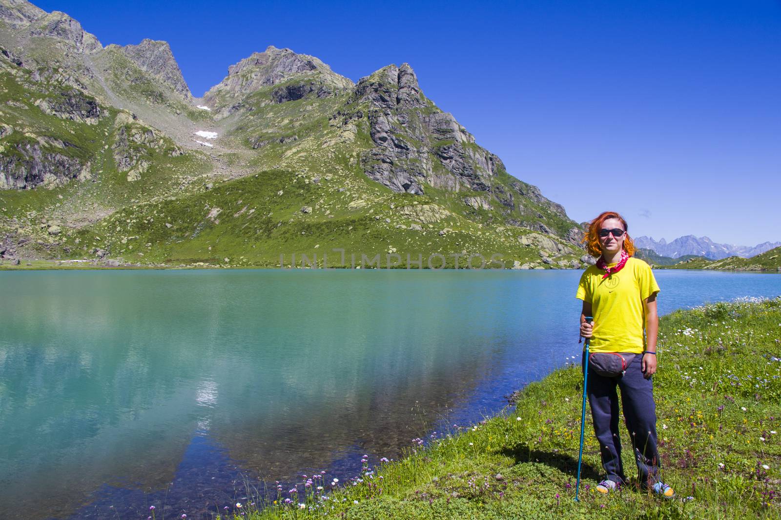 Hiker and backpacker in the mountain valley and field, trekking and hiking scene in Svaneti, Georgia, young and adult woman.