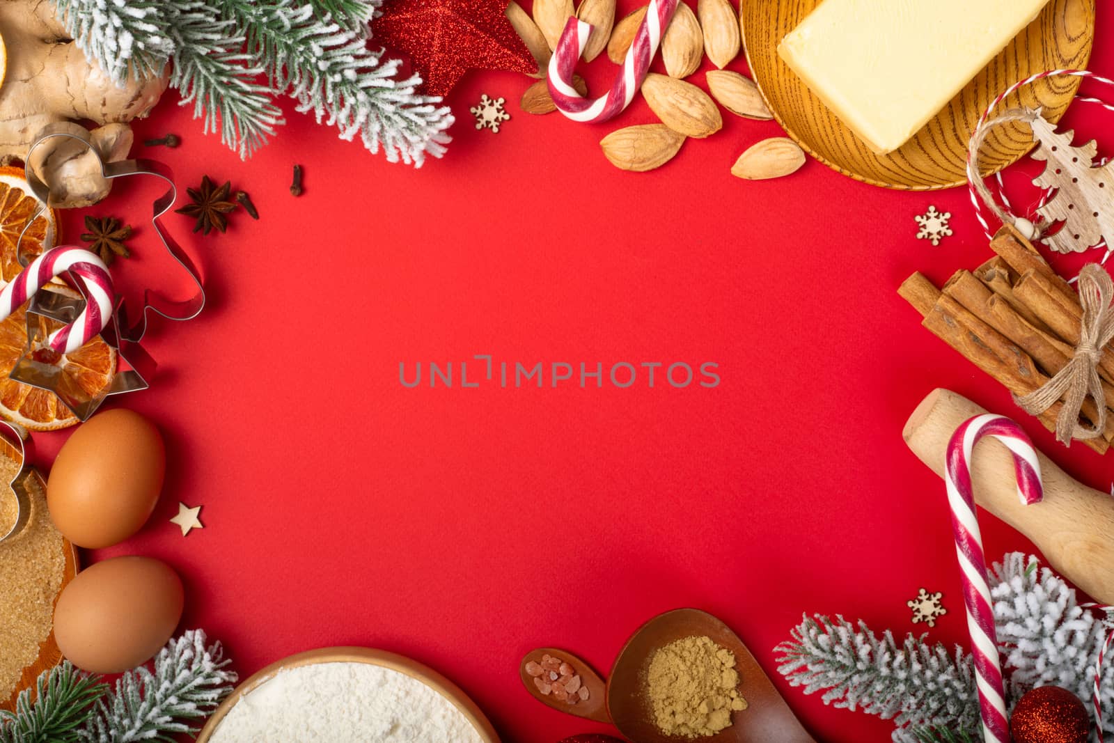 Christmas gingerbread cookies cooking background flat lay top view template with copy space for text. Baking utensils, spices and food ingredients on red paper