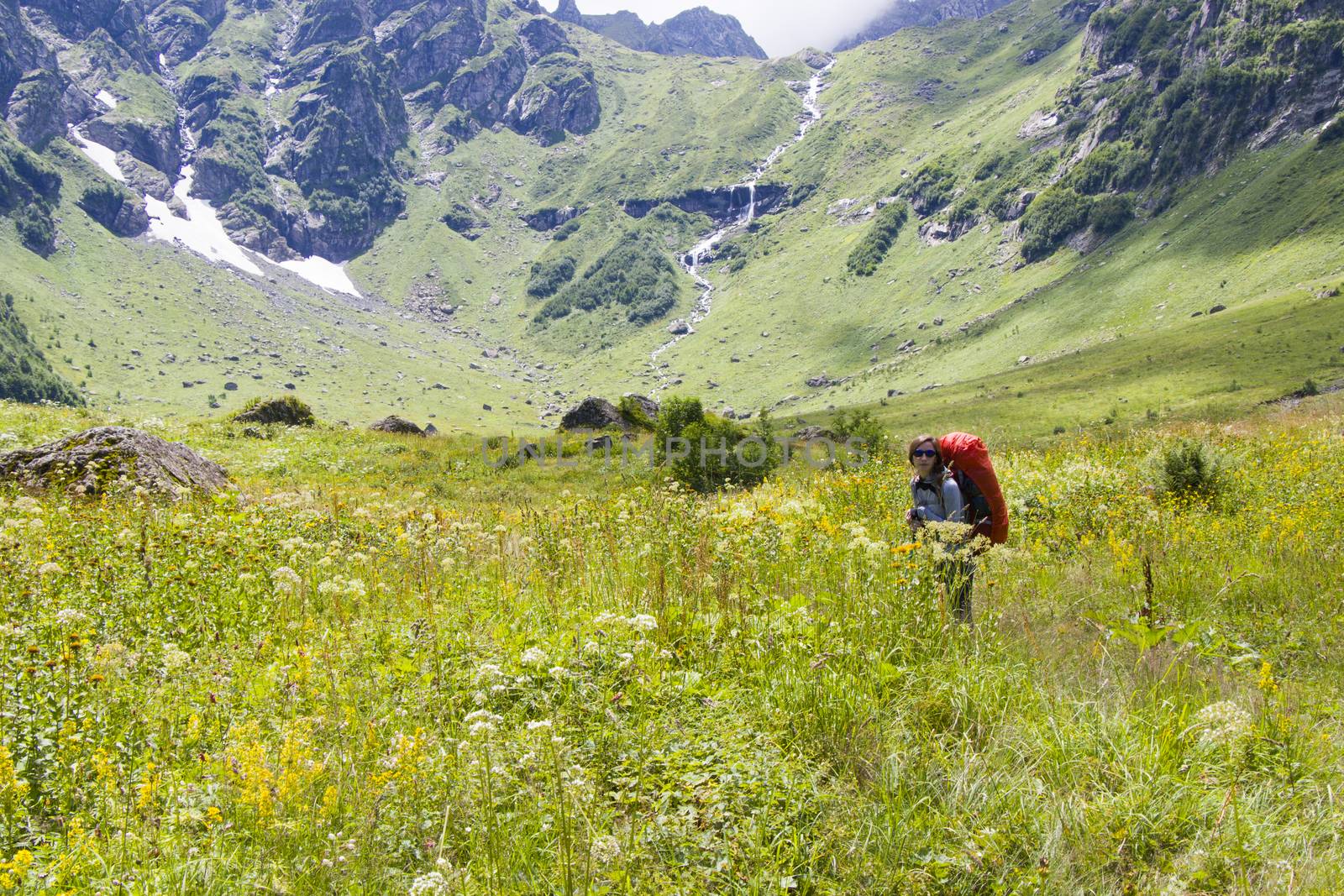 Hiker and backpacker in the mountain valley and field, trekking and hiking scene in Svaneti, Georgia by Taidundua