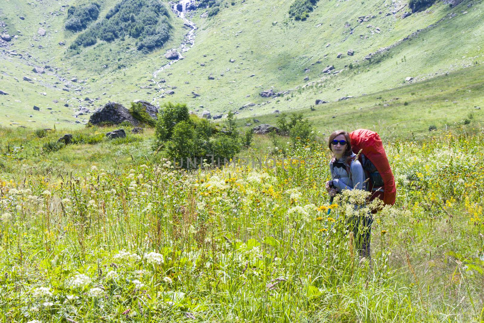 Hiker and backpacker in the mountain valley and field, trekking and hiking scene in Svaneti, Georgia, young and adult woman.