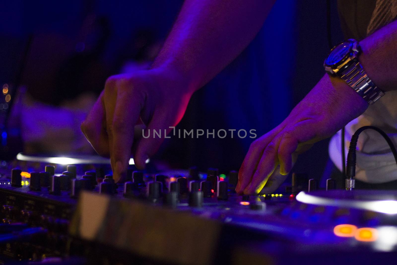 TBILISI, GEORGIA - MART 02, 2018: Night club music instrument DJ controller and DJ hands, playing music scene. Color Light Music Instrument Backgrounds. Music audio mixer.