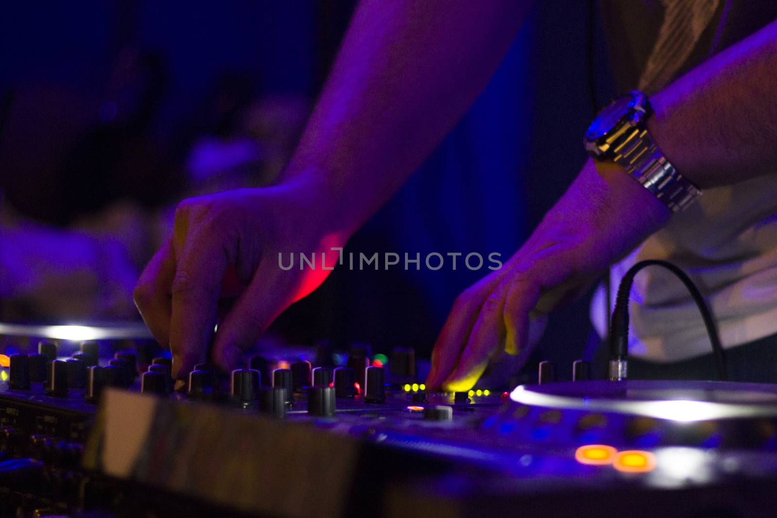 TBILISI, GEORGIA - MART 02, 2018: Night club music instrument DJ controller and DJ hands, playing music scene. Color Light Music Instrument Backgrounds. Music audio mixer.