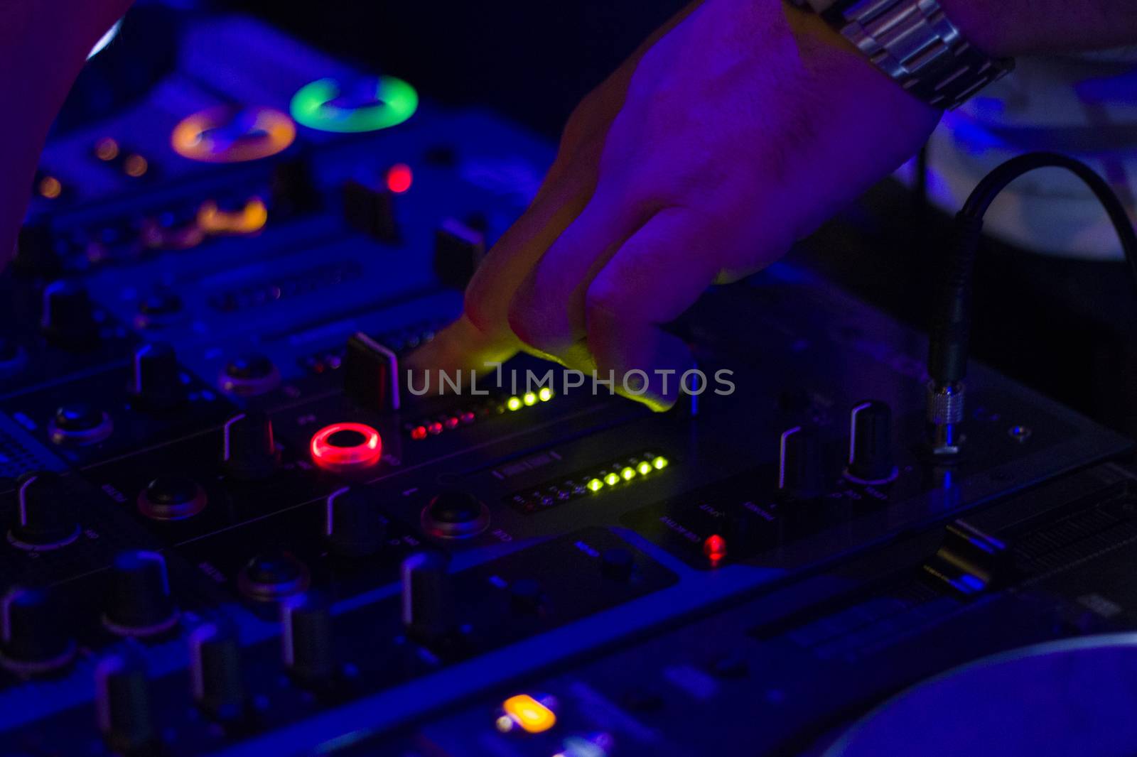 DJ controller and DJ hands, playing music scene. Color Light Music Instrument Backgrounds. Audio mixer and music mixing. by Taidundua
