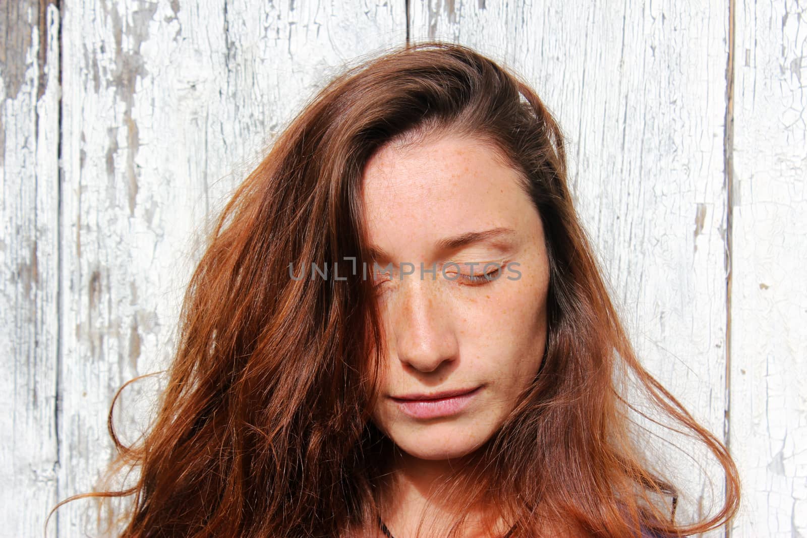 Woman portrait on the wooden background. Young beautiful ginger woman. Pretty face.