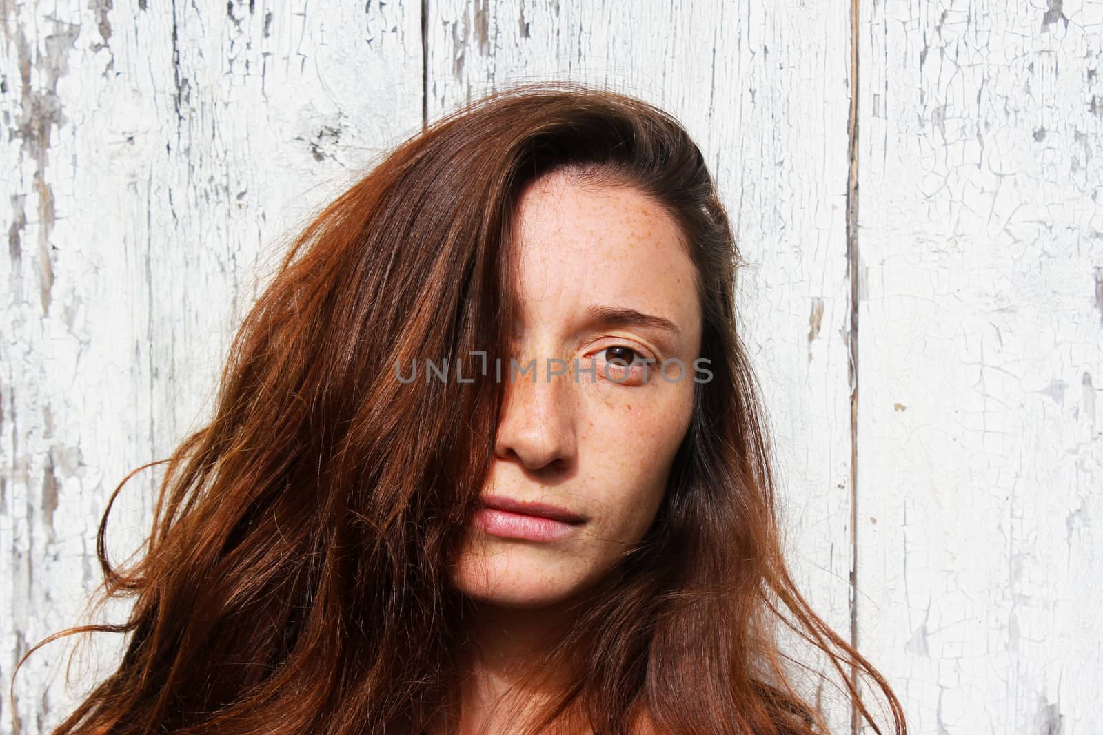 Woman portrait on the wooden background. Young beautiful ginger woman. by Taidundua