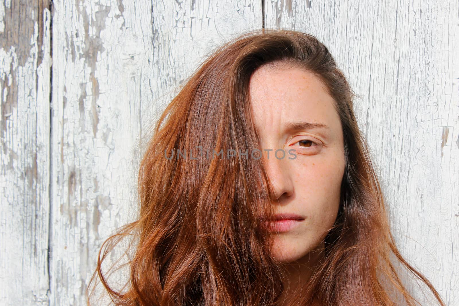 Woman portrait on the wooden background. Young beautiful ginger woman. by Taidundua