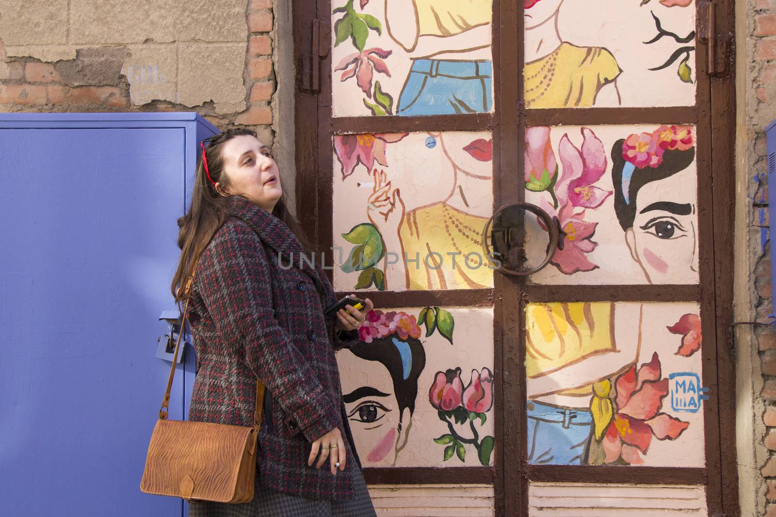 Young woman portrait, beautiful girl, pretty and cute girl on the building and architecture door background. Tourist scene.