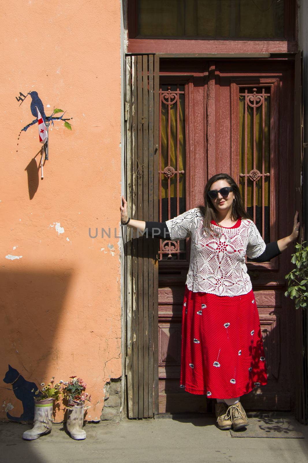 Young woman portrait, beautiful girl on the building and architecture door background. Tourist scene. by Taidundua