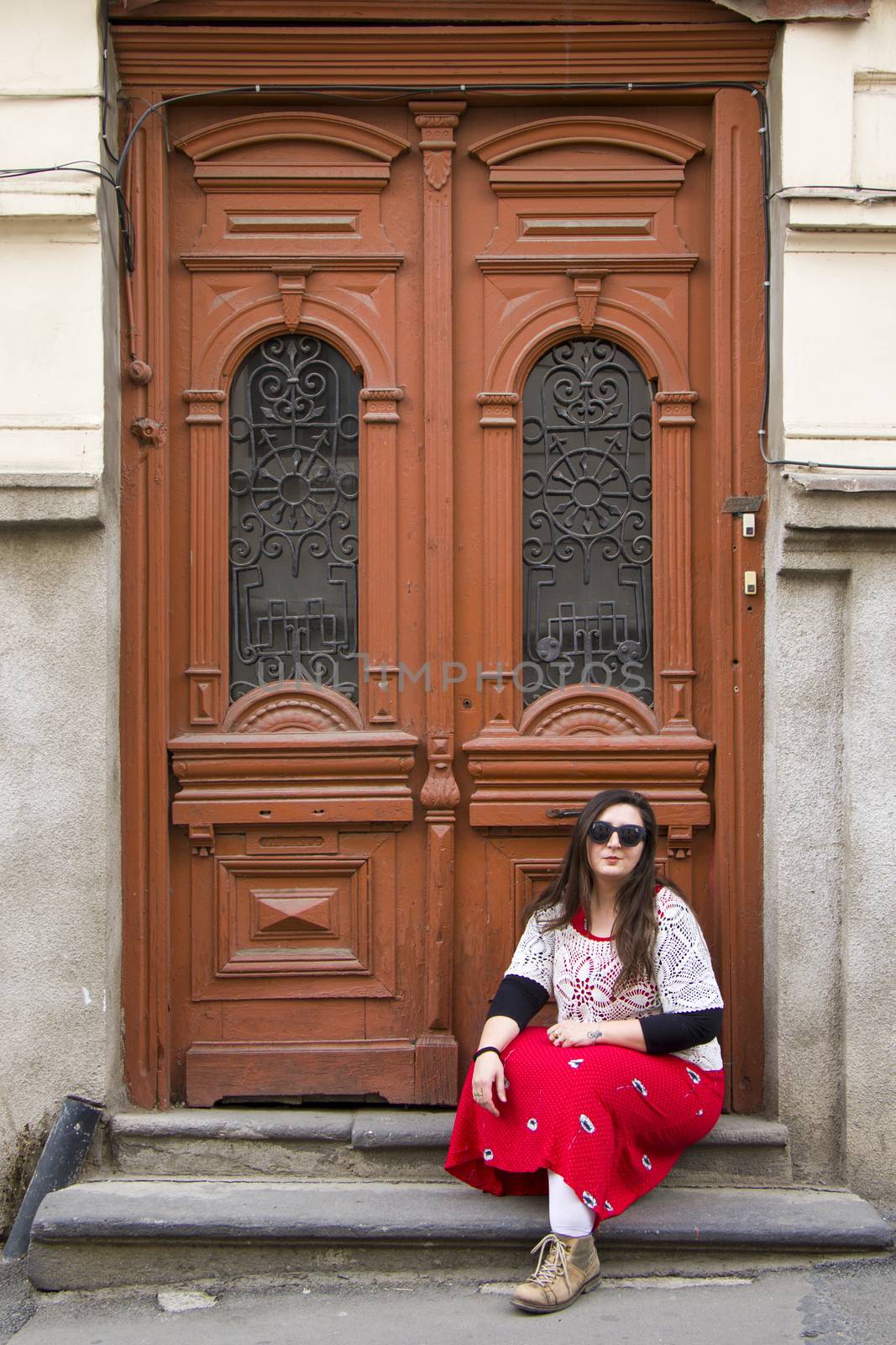 Young woman portrait, beautiful girl, pretty and cute girl on the building and architecture door background. Tourist scene.