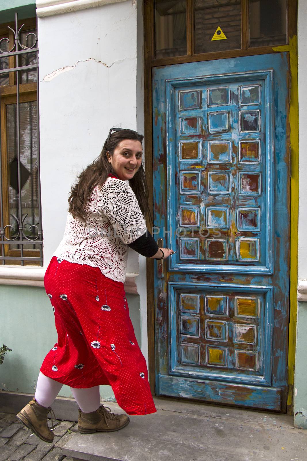 Young woman portrait, beautiful girl, pretty and cute girl on the building and architecture door background. Tourist scene.