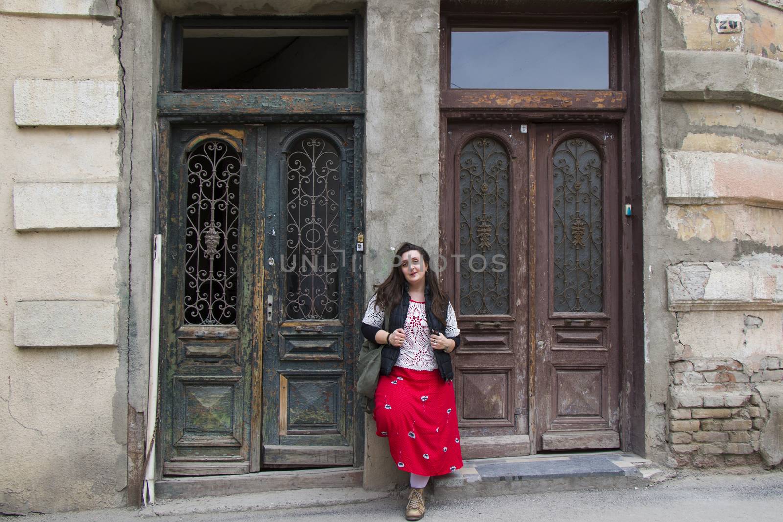 Young woman portrait, beautiful girl on the building and architecture door background. Tourist scene. by Taidundua