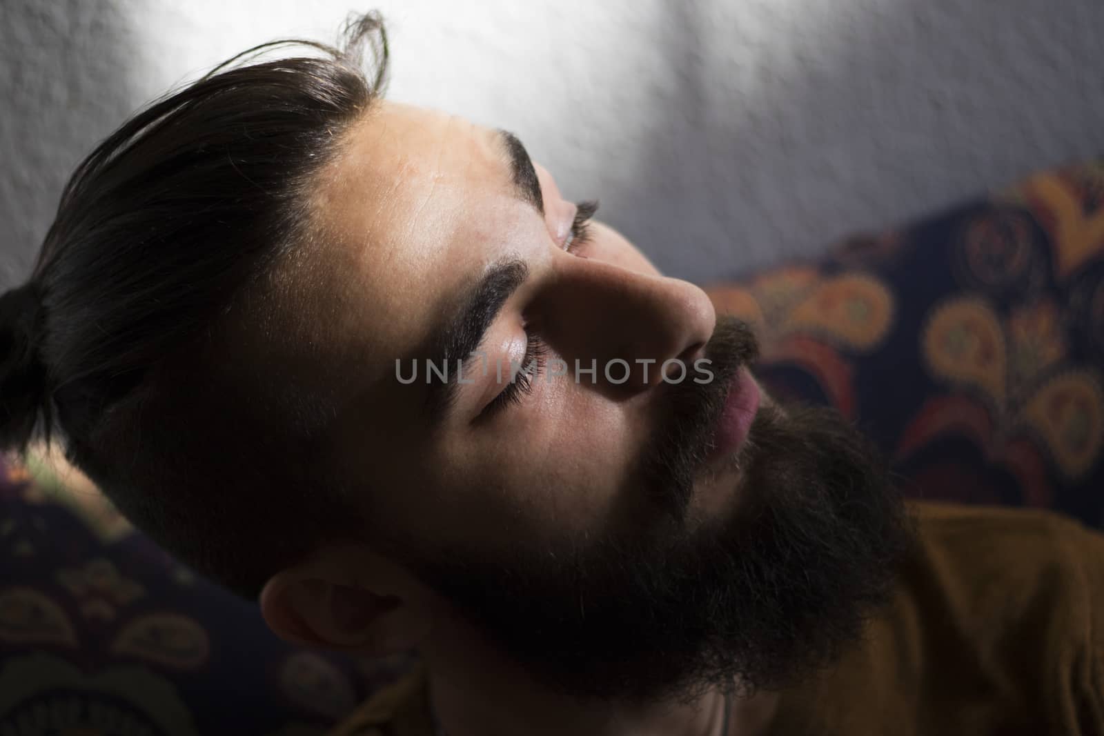 Handsome serious man portrait on the dark background, sunlight and room.