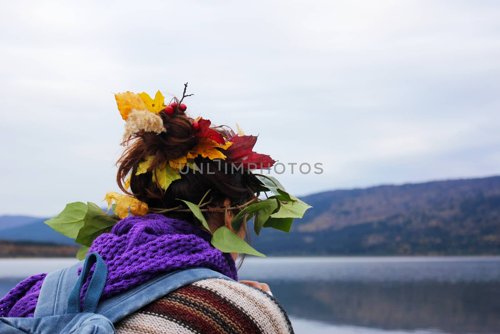 Young girl traveler with autumn leaves in hair by Taidundua