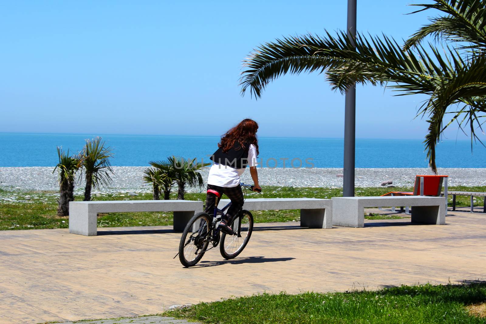 Girl on the bicycle near sea beach, sea holiday situation by Taidundua