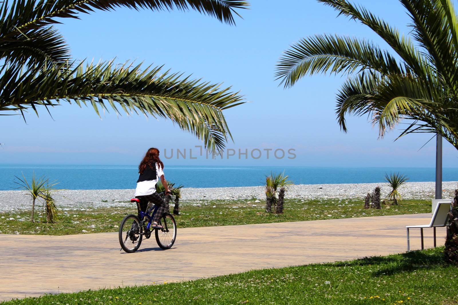 Girl on the bicycle near sea beach, sea holiday situation in Georgia