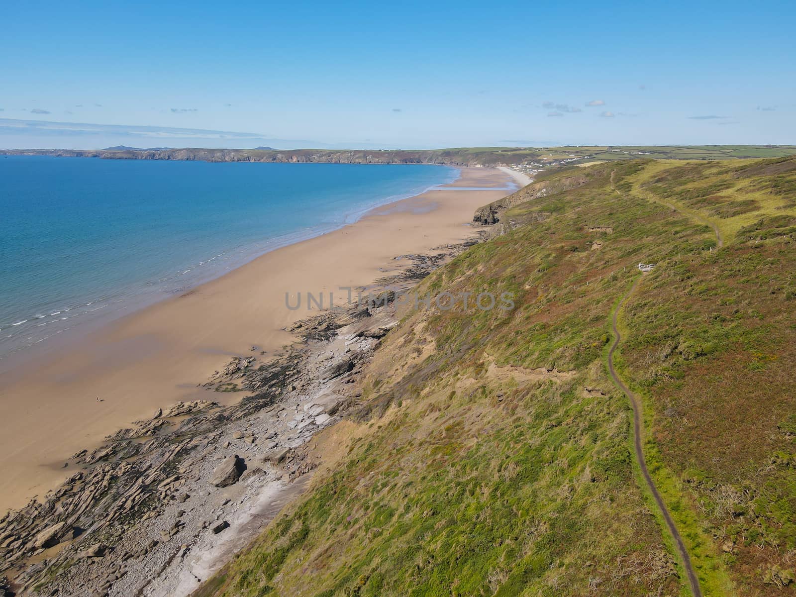 Drone Shot of Newgale Beach, Pembrokeshie, Wales, UK from public land showing stunning coastal views with a light blue ocean.