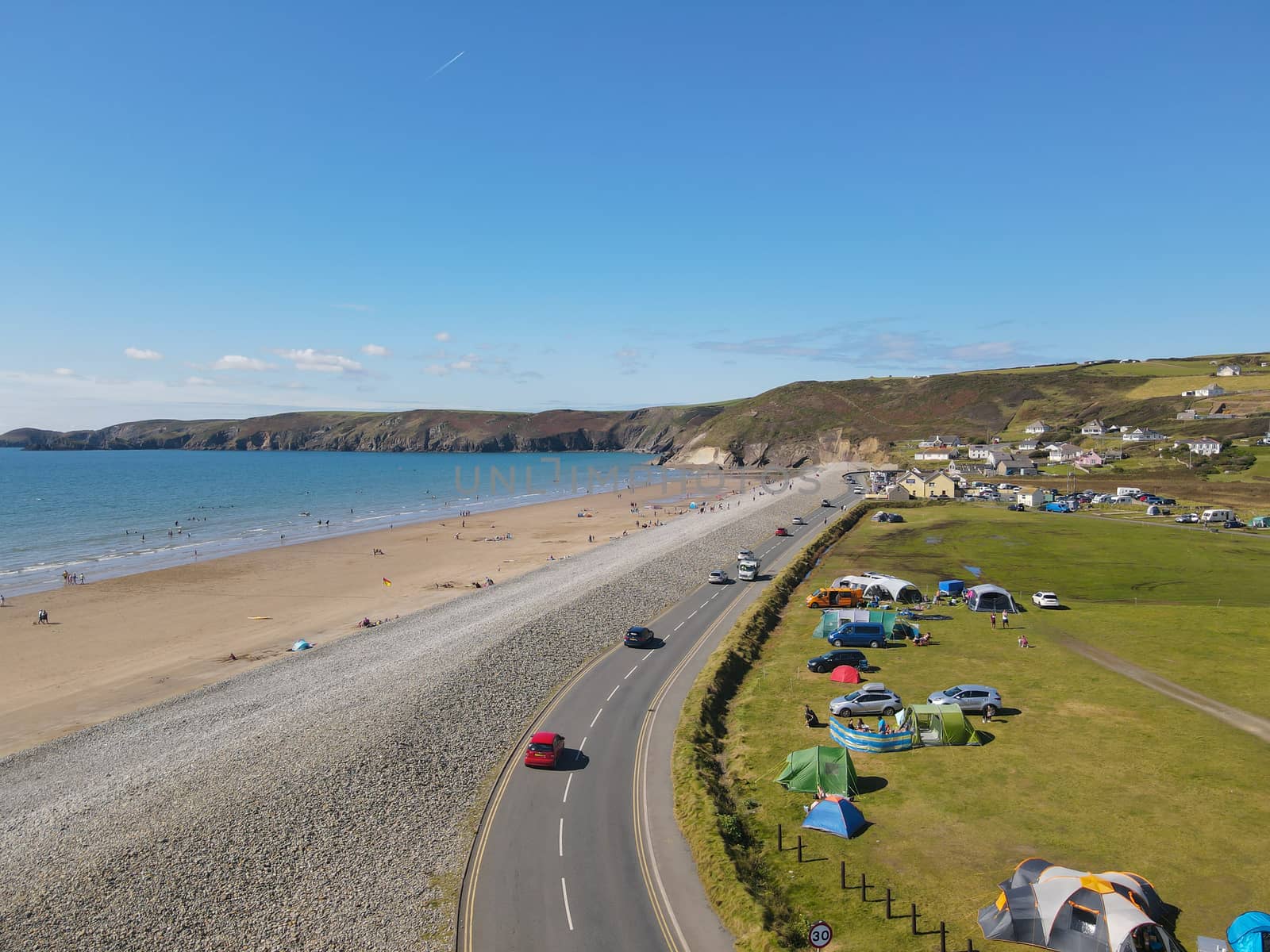 Ariel Shot: Approaching Newgale Beach, Pembrokeshire, Wales, UK from the public road. Stunning ocean views from the coast with a light blue sea and a nearby camp site.