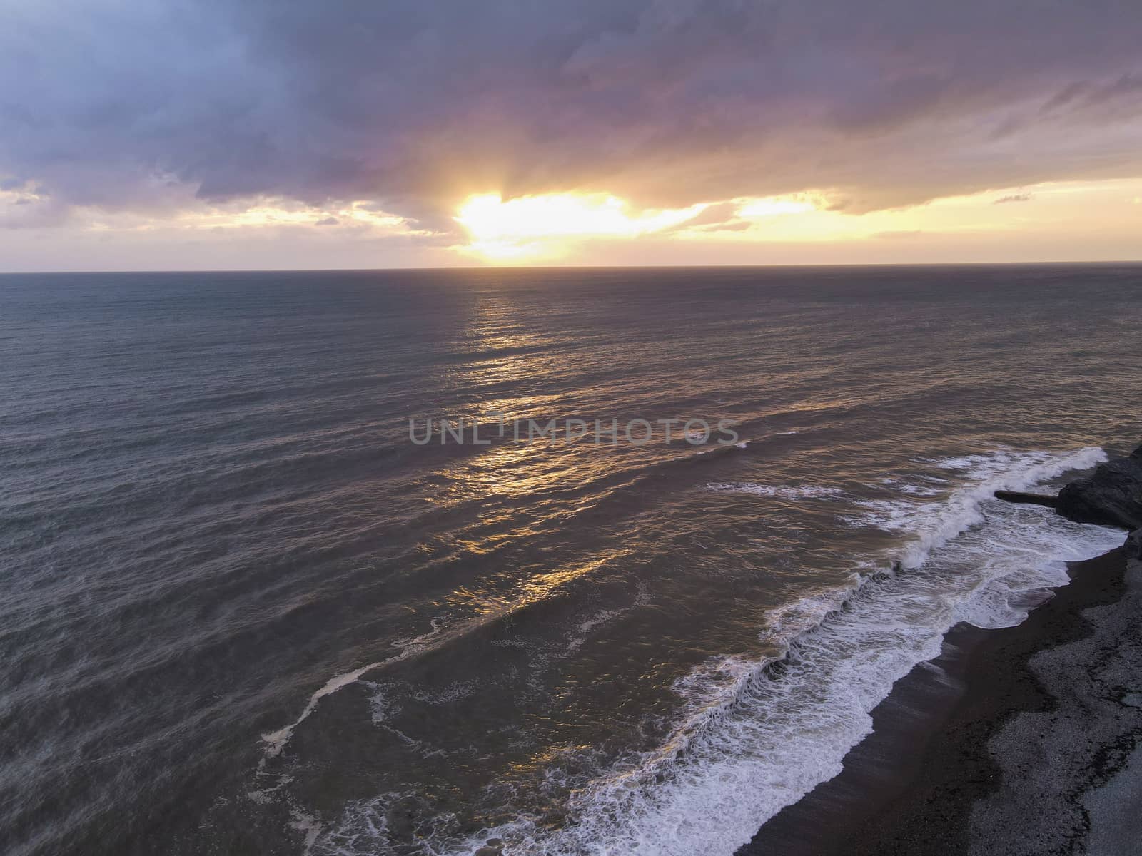 A ocean sunset at Aberystwyth, Ceredigion, Wales, UK. A coastal view of the sun setting over the Irish Sea.